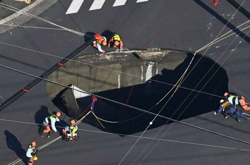 swimming-pool-sized-sinkhole-swallows-truck-on-busy-road,-trapping-driver